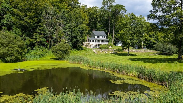 surrounding community featuring a water view and a lawn