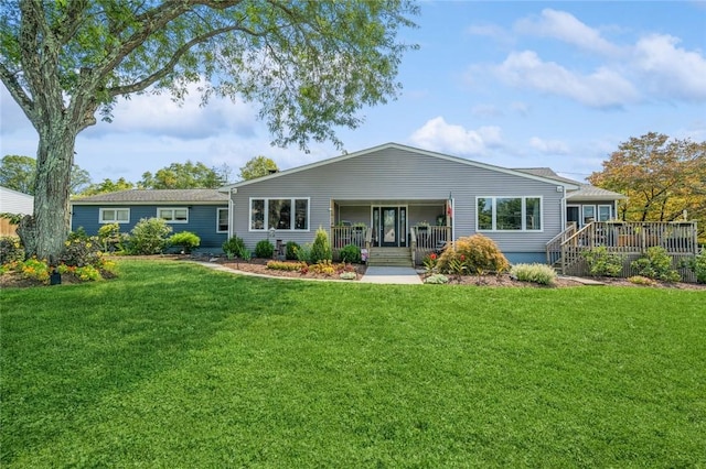 rear view of property featuring a lawn and a porch