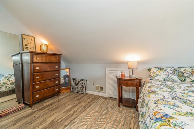 bedroom with hardwood / wood-style floors and lofted ceiling