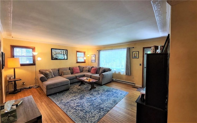 living room with ornamental molding, light hardwood / wood-style floors, and a baseboard heating unit