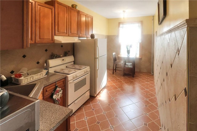 kitchen featuring decorative backsplash and white appliances