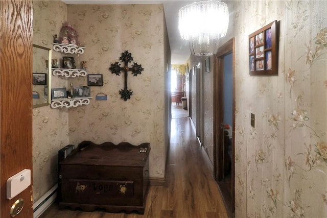 hallway featuring dark hardwood / wood-style flooring, a baseboard radiator, and a notable chandelier