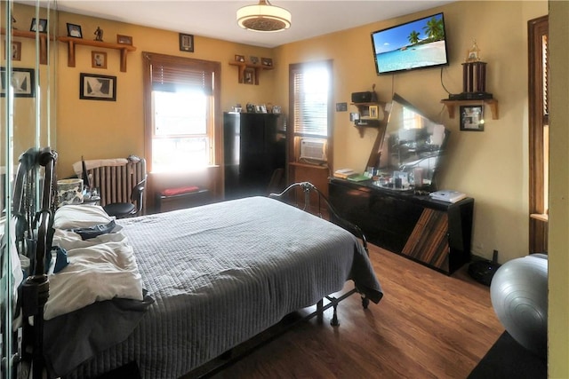 bedroom featuring dark hardwood / wood-style floors, cooling unit, and radiator heating unit