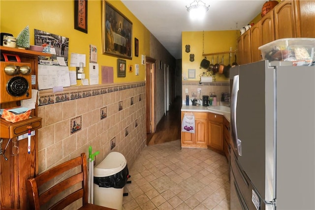 kitchen with stainless steel fridge and tile walls