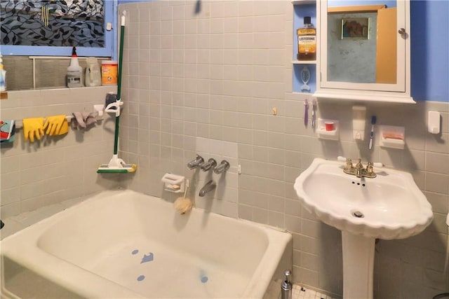 bathroom featuring tile walls and a tub