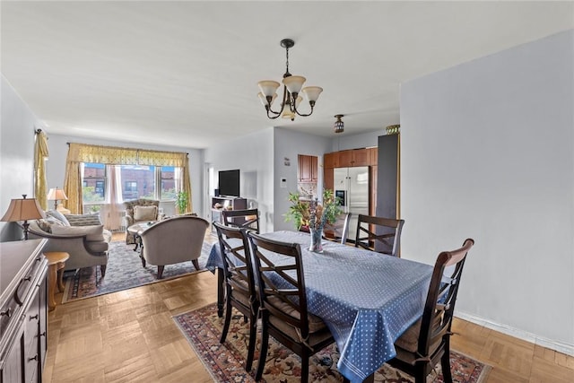 dining area with light parquet flooring and a chandelier