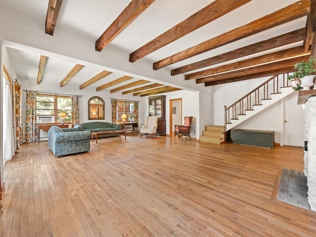 unfurnished living room with light hardwood / wood-style floors and beam ceiling