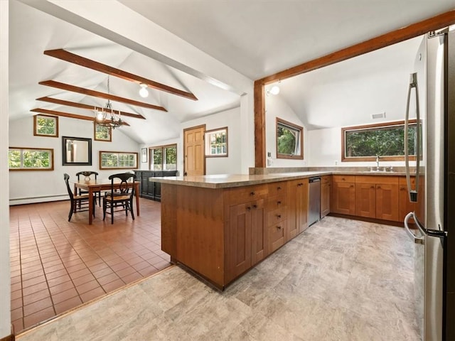 kitchen with pendant lighting, vaulted ceiling with beams, baseboard heating, and appliances with stainless steel finishes