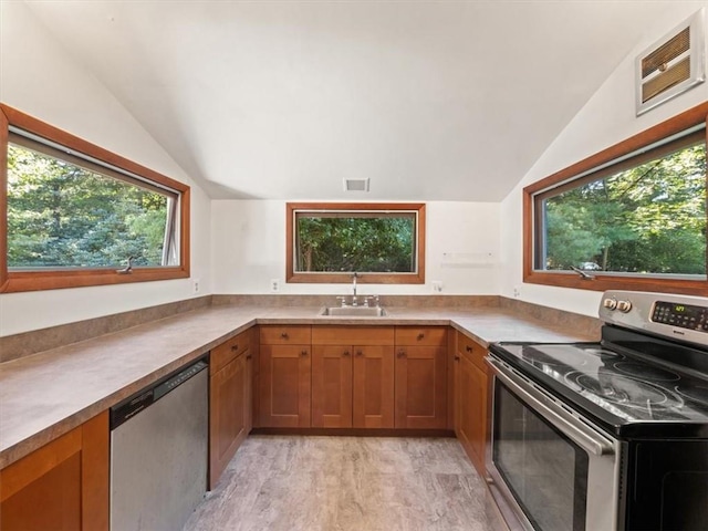 kitchen featuring sink, light wood-type flooring, stainless steel appliances, and vaulted ceiling