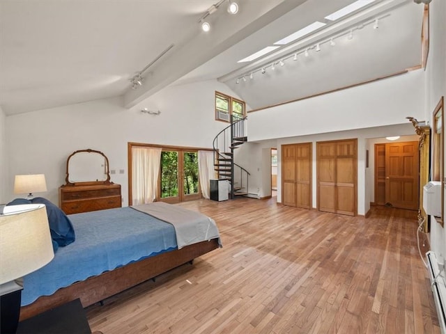 bedroom with beamed ceiling, light hardwood / wood-style floors, high vaulted ceiling, and track lighting