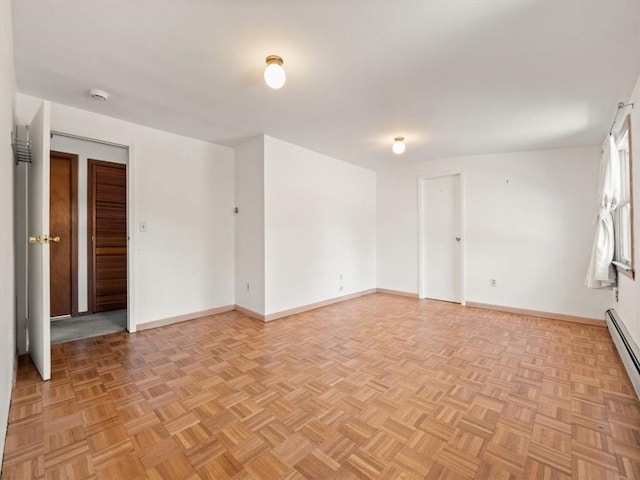 unfurnished room with baseboard heating and light parquet floors