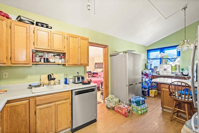 kitchen featuring sink, light hardwood / wood-style floors, lofted ceiling, light brown cabinetry, and appliances with stainless steel finishes