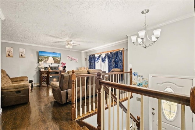 living room featuring a textured ceiling, ceiling fan with notable chandelier, hardwood / wood-style flooring, and crown molding