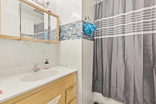 bathroom featuring vanity and tile walls