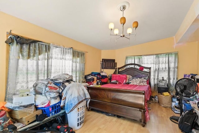 bedroom with a chandelier and light hardwood / wood-style flooring