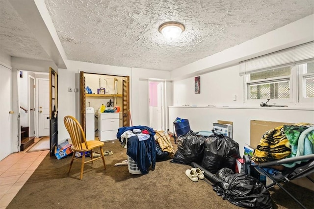 interior space featuring tile patterned floors, a textured ceiling, and washer / clothes dryer