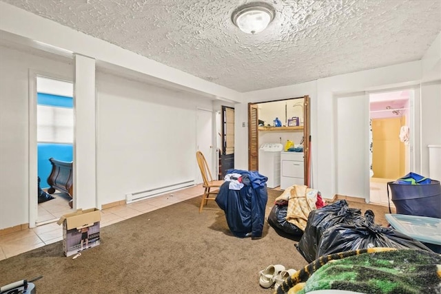 interior space featuring carpet flooring, washing machine and dryer, baseboard heating, and a textured ceiling