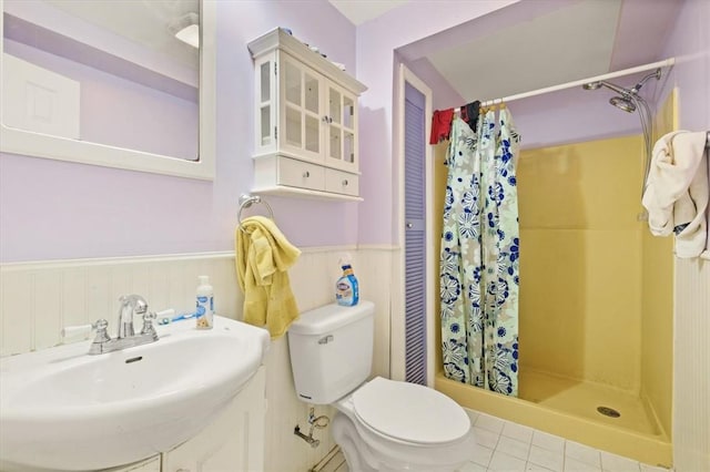 bathroom featuring tile patterned floors, toilet, walk in shower, and sink