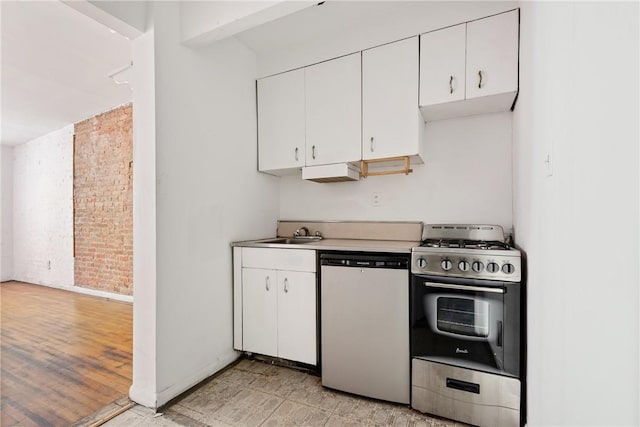 kitchen featuring appliances with stainless steel finishes, light wood-type flooring, white cabinetry, and sink