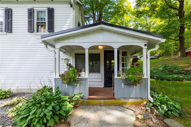 view of exterior entry featuring covered porch