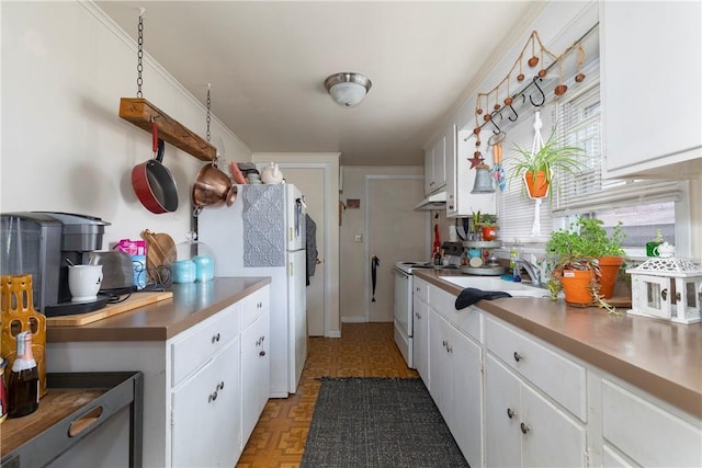 kitchen with white cabinetry, sink, and white appliances