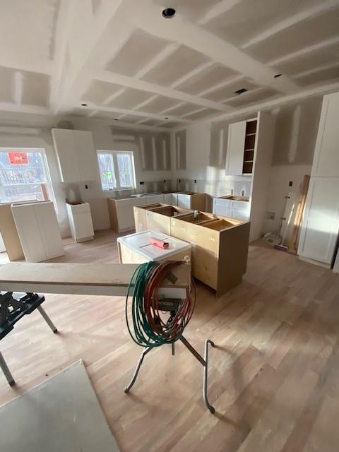 kitchen featuring white cabinetry, light hardwood / wood-style flooring, and a kitchen island