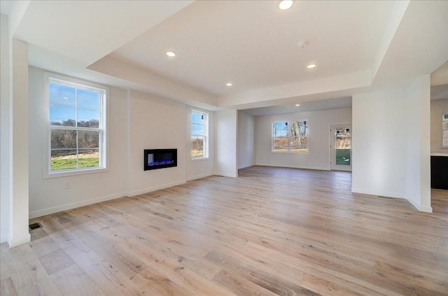 unfurnished living room featuring light hardwood / wood-style floors and a wealth of natural light