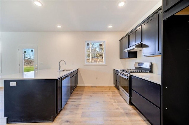 kitchen featuring kitchen peninsula, stainless steel appliances, light hardwood / wood-style floors, and sink