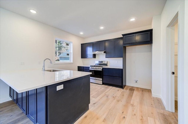 kitchen with kitchen peninsula, light hardwood / wood-style floors, stainless steel range with gas cooktop, and sink