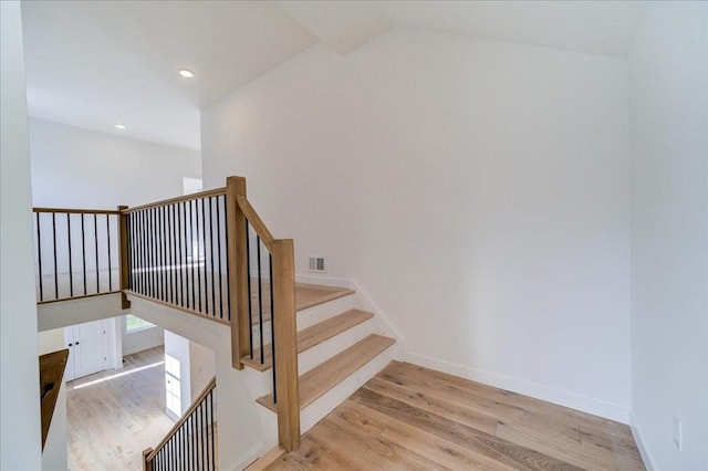 staircase featuring hardwood / wood-style floors and vaulted ceiling