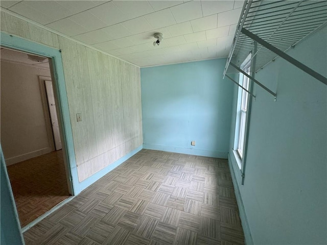 spare room with light parquet floors and wood walls