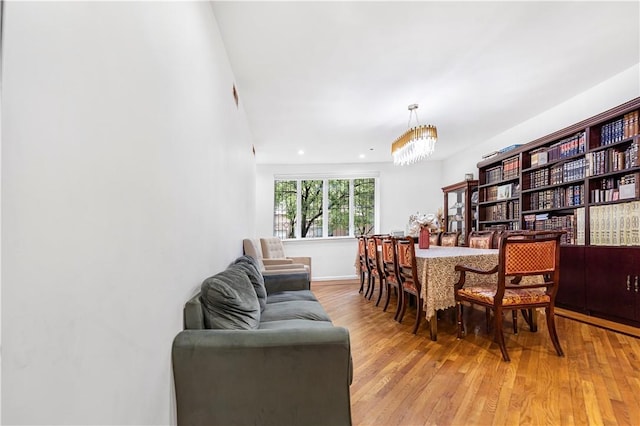 dining room with light hardwood / wood-style flooring and a notable chandelier