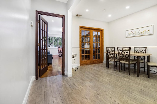 dining area featuring french doors and light hardwood / wood-style floors