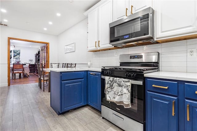 kitchen featuring white cabinetry, stainless steel appliances, and blue cabinets