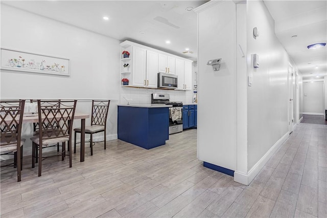 kitchen with light wood-type flooring, blue cabinets, and stainless steel appliances