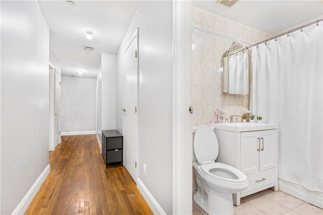 full bathroom with hardwood / wood-style flooring, vanity, toilet, and shower / bathtub combination with curtain