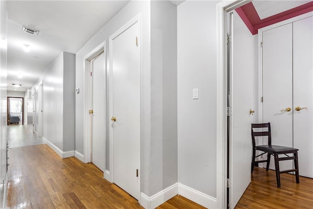 corridor with hardwood / wood-style flooring