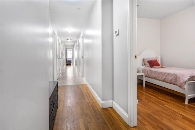 corridor with hardwood / wood-style floors