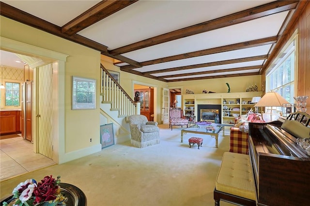 living room featuring beamed ceiling, plenty of natural light, and light tile patterned floors