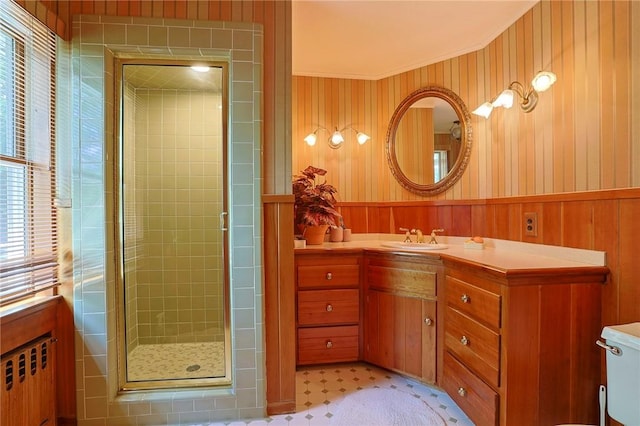 bathroom featuring a shower with door, tile patterned flooring, radiator heating unit, toilet, and wood walls