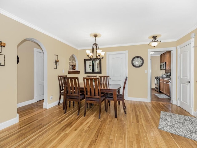 dining room with crown molding, an inviting chandelier, and light wood-type flooring