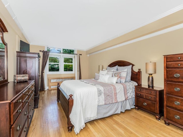 bedroom with crown molding and light hardwood / wood-style floors