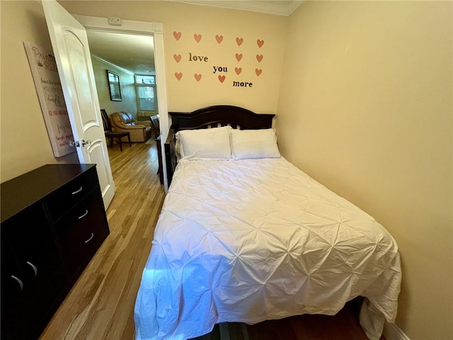 bedroom with hardwood / wood-style flooring and crown molding