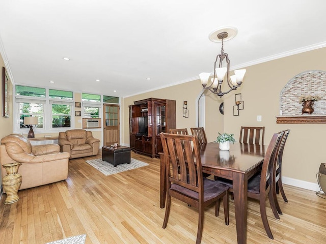 dining area featuring light hardwood / wood-style flooring, ornamental molding, and a notable chandelier