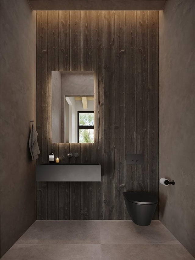 bathroom with wood walls and toilet