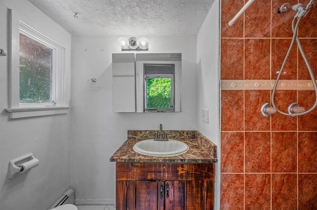 bathroom featuring a shower, a textured ceiling, vanity, and toilet