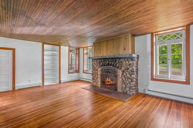 unfurnished living room featuring light wood-type flooring, a stone fireplace, a baseboard heating unit, and wood ceiling