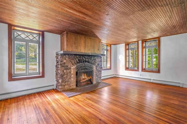 unfurnished living room featuring plenty of natural light, wood ceiling, and a baseboard radiator