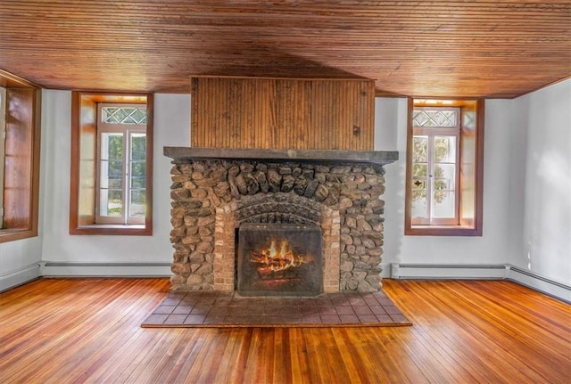 interior space with a fireplace, wood-type flooring, a baseboard heating unit, and wood ceiling