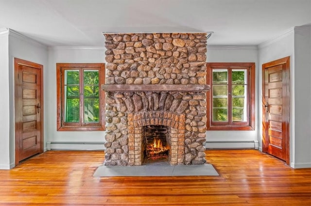 unfurnished living room with a stone fireplace, a baseboard radiator, light wood-type flooring, and ornamental molding